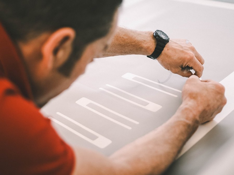 Mitarbeiter in der Werbetechnik-Produktion bei der Anfertigung von Beschriftungen.