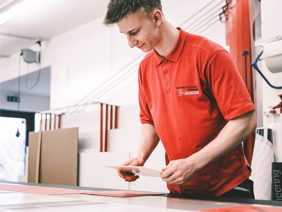 Ein Lehrling druckt Schilder, Ausbildung in Werbetechnik in Altenmarkt, Salzburg